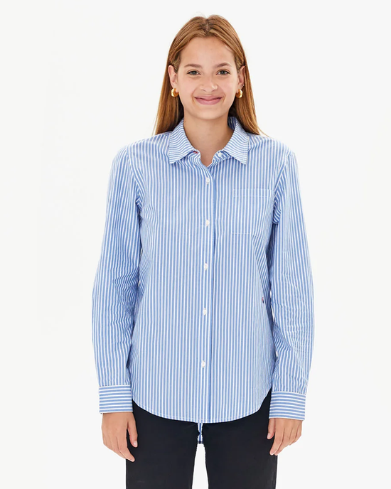 Woman in a tailored fit, Clare V. Phoebe Blouse in Blue & Cream Stripe, smiling at the camera.