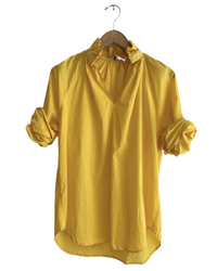 Yellow Penelope - Cabo in Sun blouse with a ruffle collar on a hanger against a white background by A Shirt Thing.