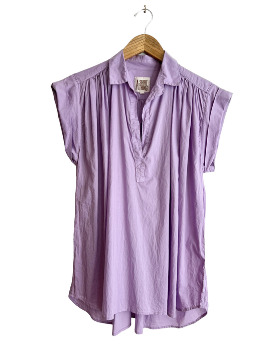 A Liv - Cabo in Lilac sleeveless V-neck blouse hanging on a wooden hanger against a white background by A Shirt Thing.