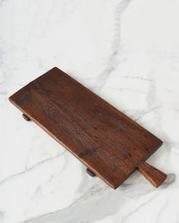 The etúHOME Bordeaux Footed Tray, crafted from wood with a handle, doubles as a serving tray and sits elegantly on a marble surface in this rustic modern kitchen.