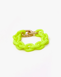 Bright neon yellow resin link bracelet with a gold-colored double carabiner closure on a white background by Clare V.