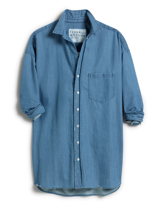 A blue Italian color denim Shirley Oversized Button-Up Shirt in Vintage Stonewashed Indigo with rolled-up sleeves and a chest pocket, displayed on a white background by Frank & Eileen.