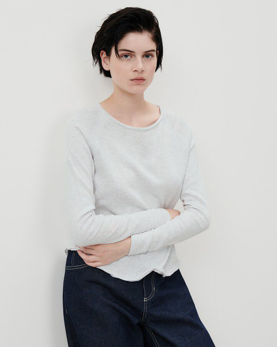 Woman in a Sonoma L/S Scoop in Arctique Chine top made from organic cotton and blue jeans standing with arms crossed.