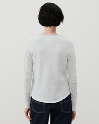 Person standing with their back to the camera wearing an American Vintage Sonoma L/S Scoop in Arctique Chine top and blue jeans.