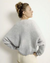 Woman with hair in a bun wearing an American Vintage grey oversized Damsville Boatneck Sweater in Gris Chine viewed from behind.