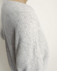 Side view of a person wearing an American Vintage Damsville Boatneck Sweater in Gris Chine, focusing on the upper body and arm.