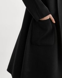 Person with hand in the pocket of an oversized Lamarque Thara Jacket in Black made from double-faced wool.