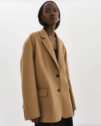 A woman in a tailored Lamarque Ennis Jacket in Camel with large buttons.