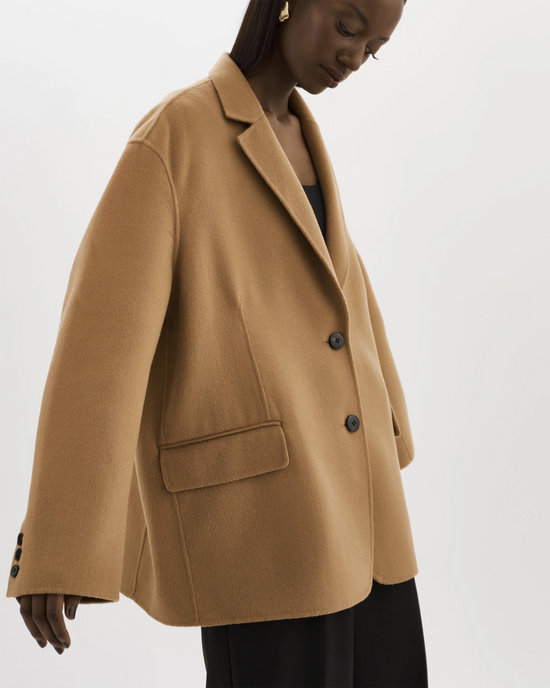 A woman showcasing a Lamarque Ennis Jacket in Camel with button details.