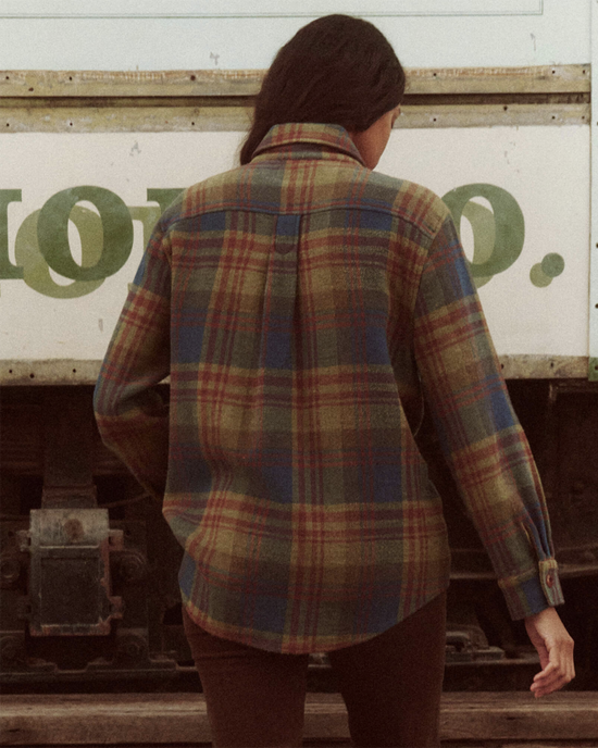 Woman standing in front of a truck with her back to the camera, wearing The Craftsman Jacket in Sequoia Plaid by the Great.
