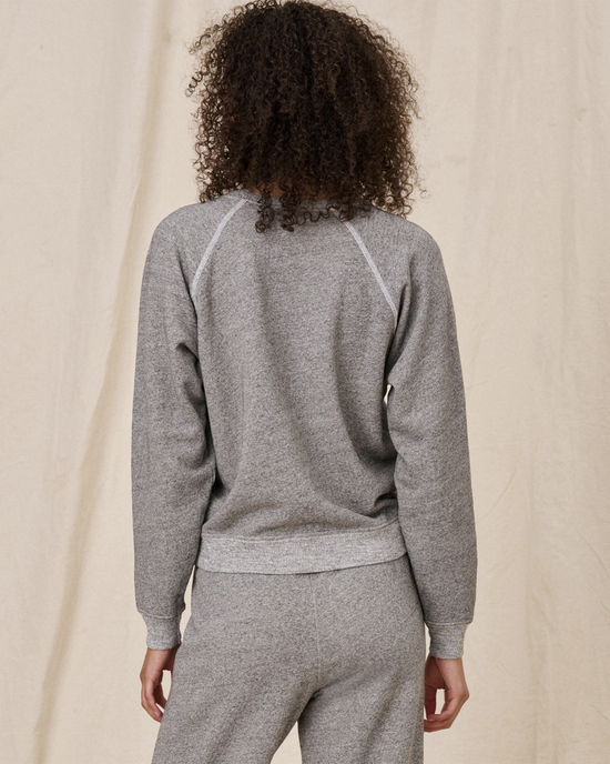 Person standing with their back to the camera wearing The Shrunken Sweatshirt in Varsity Grey by the Great in a cropped fit.