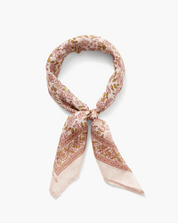 A Vintage Floral Bandana in Mauve Chalk tied in a knot on a white background.