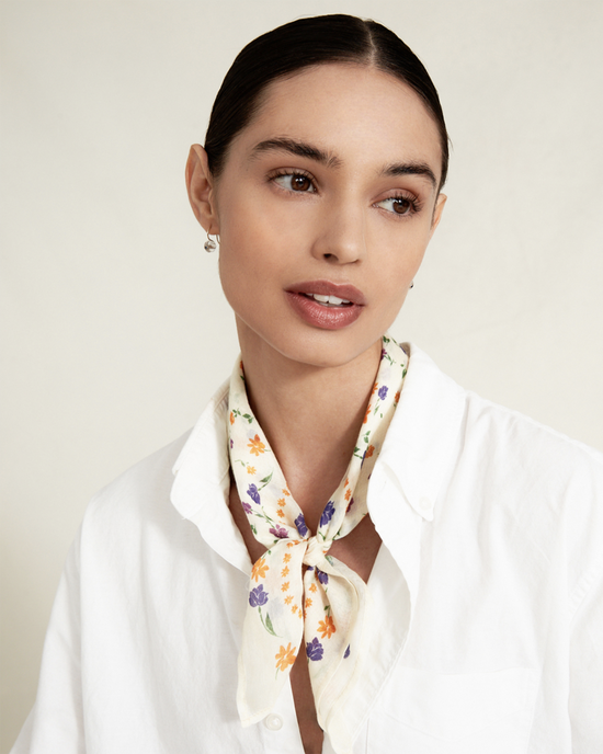Woman wearing a Chan Luu Spring Floral Bandana in Cream and white shirt.