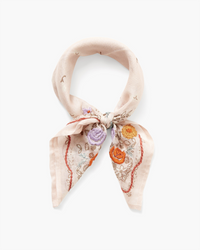 A Lrg Emb Flower Bandana in Mauve Chalk by Chan Luu with a floral and paisley embroidery tied in a knot, isolated on a white background.