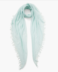 A light teal Cashmere & Silk Scarf in Aqua with fringed trims, isolated on a white background by Chan Luu.