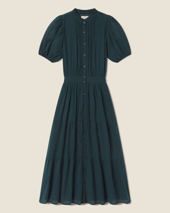 The Blair Dress in Sea Pine Check by Trovata Birds of Paradis is a dark green, ankle-length dress featuring short puff sleeves, a button-down front, fitted waist, and tiered midi skirt for an elegant look.