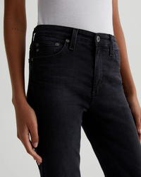 Close-up of a person wearing Mari in City View high-rise straight leg dark jeans and a white top by AG Jeans.