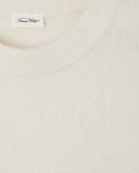 Close-up of a cream-colored crewneck Vito Crop Sweater in Blanc with an "American Vintage" brand label.
