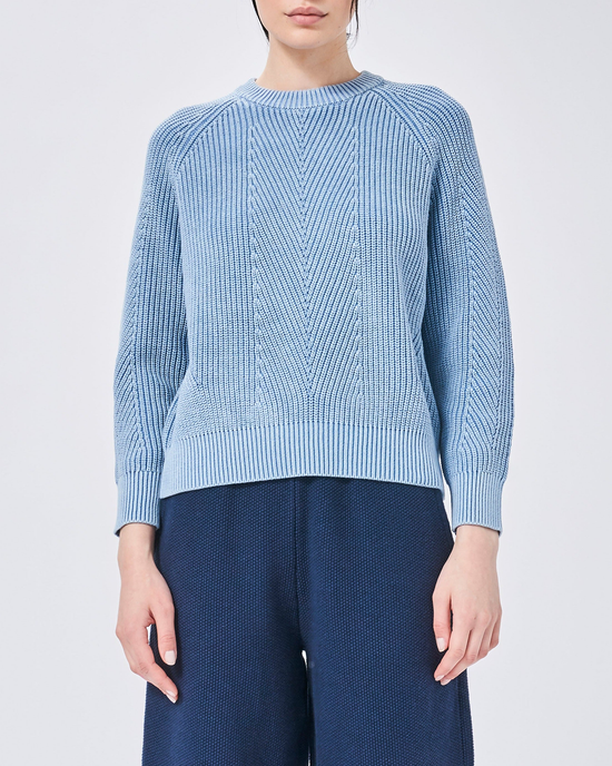 Woman wearing a Demylee Chelsea Sweater in Sky Blue with a cable knit design.