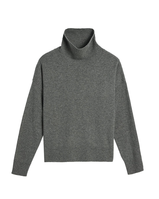 The Demylee Gianna Cashmere Turtleneck in Dark Heather Grey features long sleeves and ribbed cuffs, hem, and neck. Laid flat on a white background, it highlights its relaxed fit.