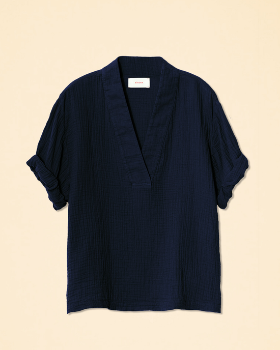 Navy blue v-neck Avery Top in North Star on a beige background, crafted from cotton gauze by XiRENA.