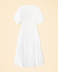 XiRENA's Lennox Dress in White, made of Cotton Gauze with puff sleeves and tiered skirt on a pastel background.