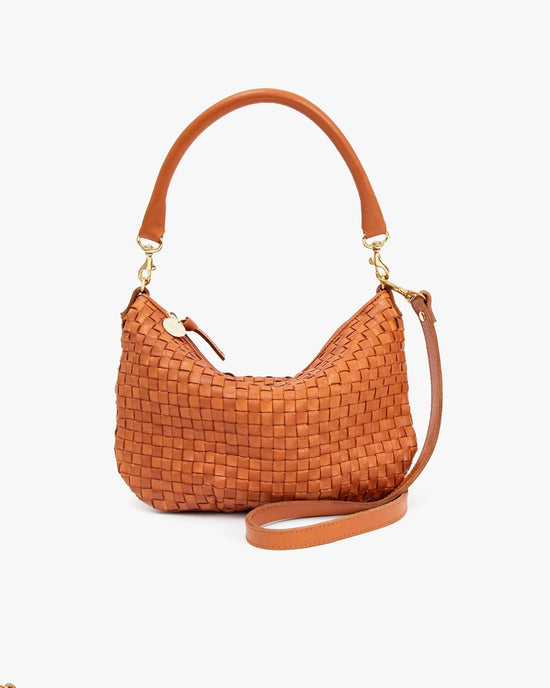 A Petite Moyen Messenger in Natural Woven Checker handbag by Clare V. with a curved top handle and a detachable shoulder strap, displayed against a white background.