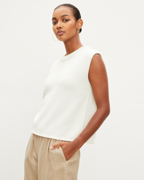 Woman in a white Velvet by Graham & Spencer Aster Cap Sleeve Crew Top in Milk and beige trousers against a plain background.