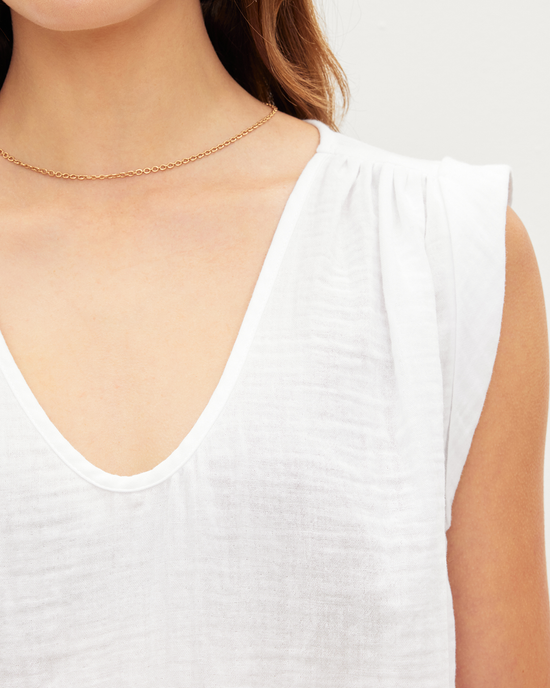 Close-up of a woman wearing a Jayla Scoop Neck Top in White with a gathered shoulder detail and a delicate chain necklace by Velvet by Graham & Spencer.