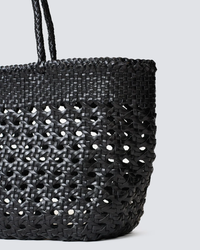 A close-up of a Dragon Diffusion black handwoven leather Cannage Kanpur Big tote bag against a plain background.