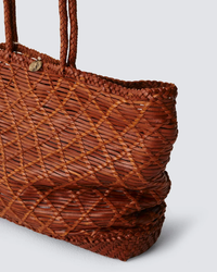 Close-up of a Dragon Diffusion EW Corso Bag in Tan featuring a crosshatch design.