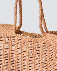 Close-up of a hand-woven tan Dragon Diffusion Window Basket in Natural against a neutral background.