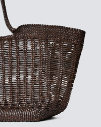 Close-up of a hand-crafted Dragon Diffusion Window Shopper in Dark Brown tote, woven from 100% leather, against a gray background.