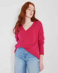 Woman in a Winter Pink Ella Cashmere V-Neck Sweater by Not Monday and blue jeans standing against a plain background.