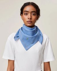 Woman wearing a white t-shirt and Mois Mont Bandana No 656 in Nordic Blue neck scarf.