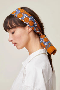 Woman wearing a Mois Mont Bandana No 680 in Terracotta and white shirt, profile view.