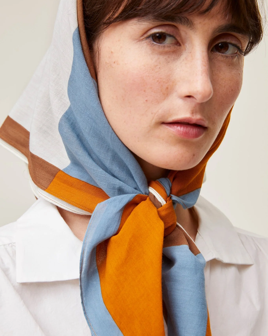Woman wearing a Mois Mont Bandana No 717 in Tobacco and a white shirt.