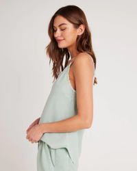Woman in a Bella Dahl Frayed Cami in Oasis Green, smiling with her eyes closed.