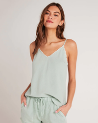 A woman wearing a Bella Dahl Frayed Cami in Oasis Green with matching shorts.