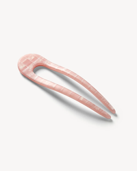 A pink Machete French Hair Pin in Apricot Shell Checker on a white background.
