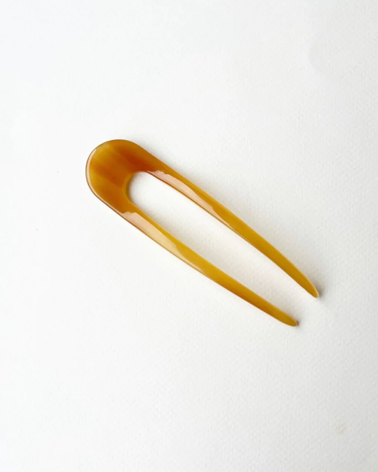 Amber-colored Machete French Hair Pin in Cognac on a white background, perfect for an effortless updo.