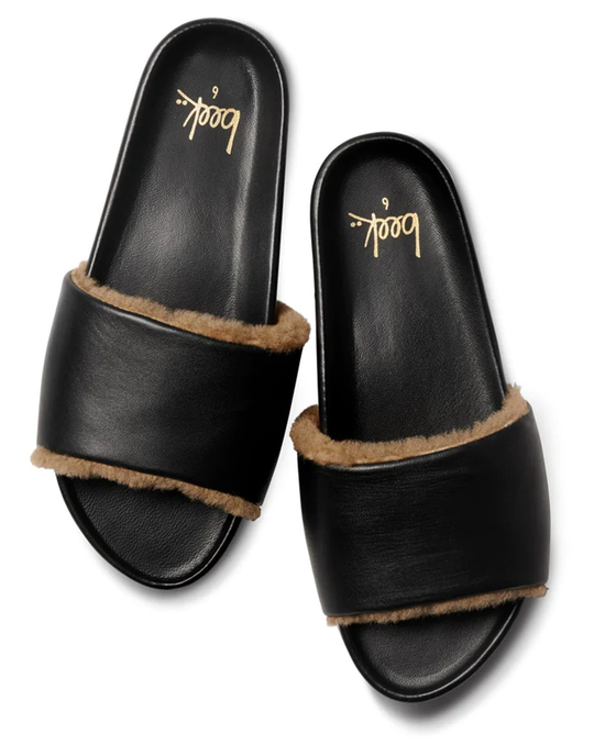 A pair of Gallito Shearling sandals in Black/Bronze by beek. with faux fur lining on a white background.