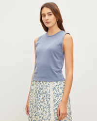 A woman wearing a sleeveless Magson Tank Top in Haze from Velvet by Graham & Spencer and a floral skirt.