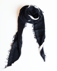The Grisal Rosa Mini in Black X Milk features frayed edges and a white stripe, shown loosely coiled on a white background.