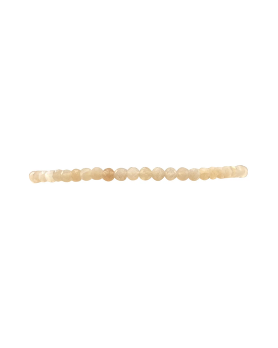 A string of Karen Lazar Design's 2MM Sig Bracelet with Nude Moonstone & Yellow Gold beads in varying shades of white and tan displayed horizontally against a white background.