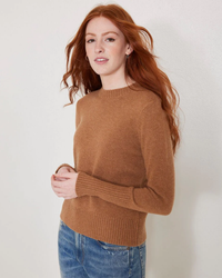 Woman with red hair wearing a brown Not Monday Mongolian Cashmere Jane Crewneck sweater and jeans.