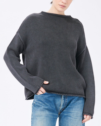 Woman wearing a Lamis Boatneck Sweater in Black by Demylee and blue jeans.