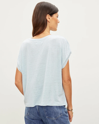 Woman wearing a casual Velvet by Graham & Spencer Hudson S/S Crew Neck Top in Stream muscle tee and denim jeans, viewed from the side.