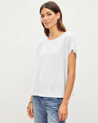 Woman in a Hudson S/S Crew Neck Top in White by Velvet by Graham & Spencer and blue jeans standing against a neutral background.
