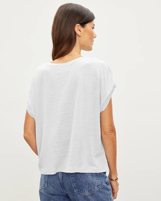 A woman viewed from the back wearing a Hudson S/S Crew Neck Top in White and blue jeans by Velvet by Graham & Spencer.